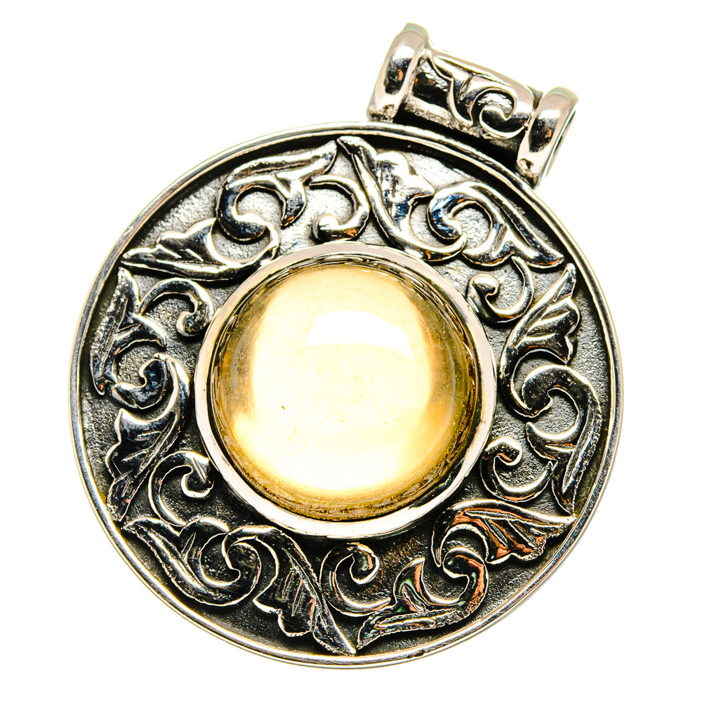 Sterling silver pendant with ornate bezel and round light amber cabochon