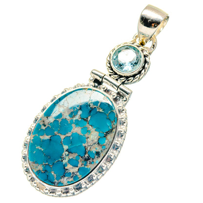 Turquoise oval pendant with small round blue gemstone and decorative silver bail