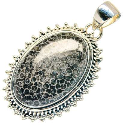 Round silver pendant with textured oval inset, beaded edge, and top bail