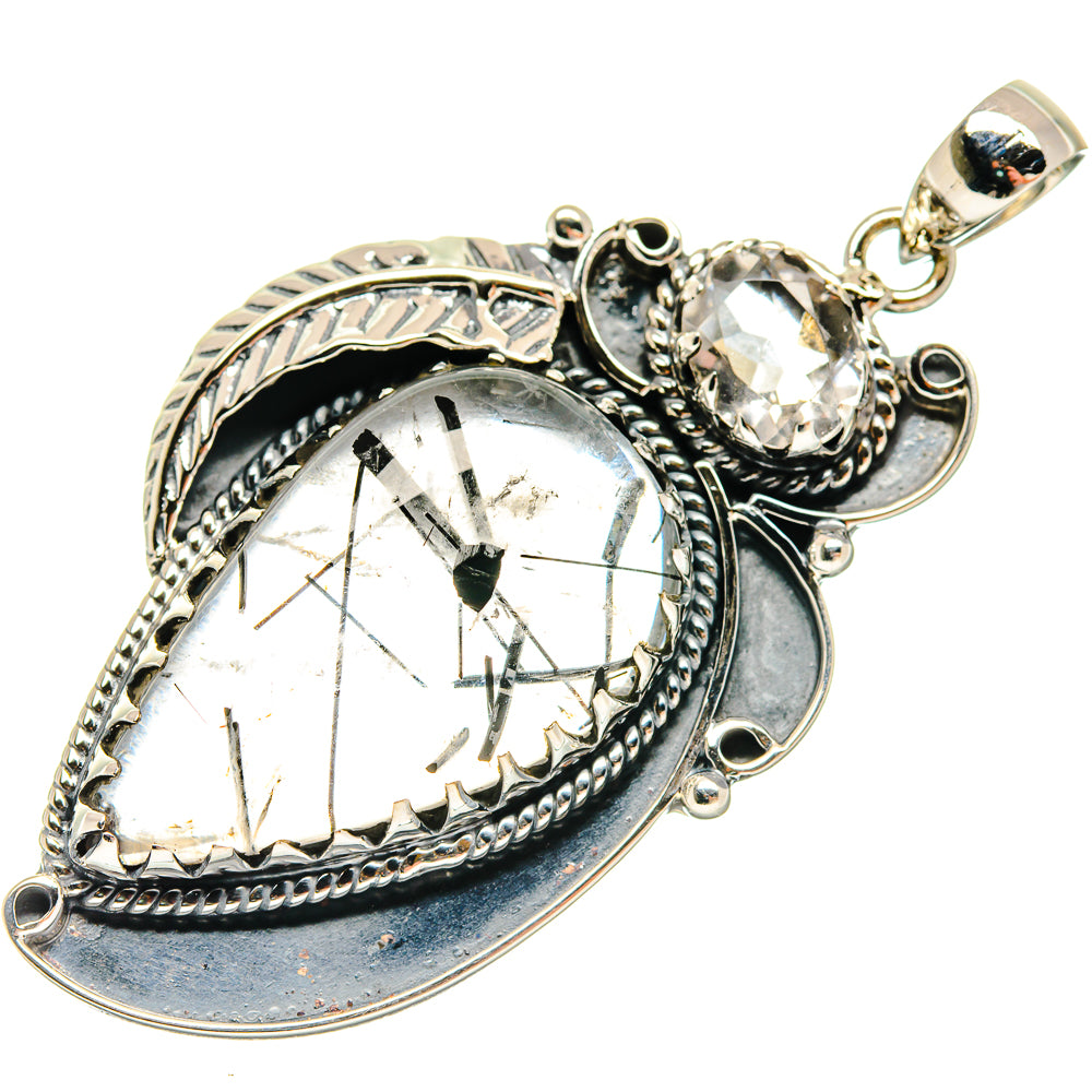 Heart-shaped silver-tone pendant with clear faceted gemstone and ornate bezel