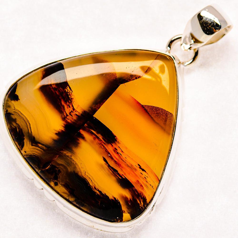Montana agate pendant in silver bezel, triangular amber-brown stone with dark streaks