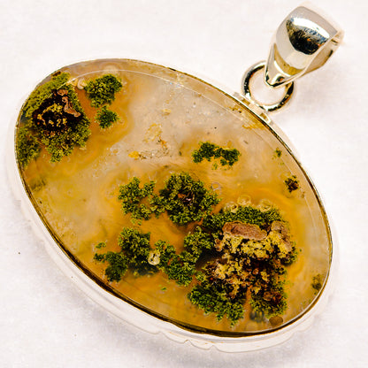 Oval plume agate pendant, yellow-amber stone with green mossy inclusions, silver frame