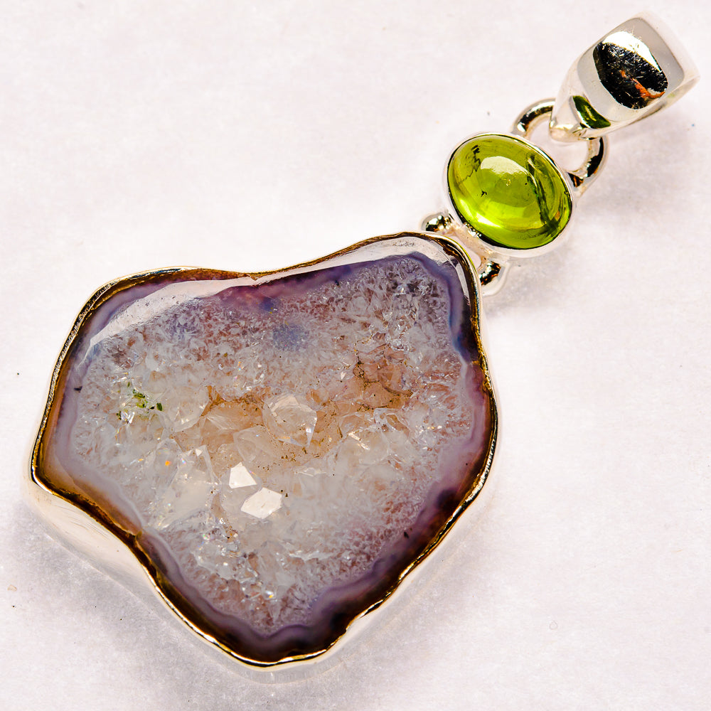 Sterling silver geode slice pendant with green peridot cabochon and white crystal center