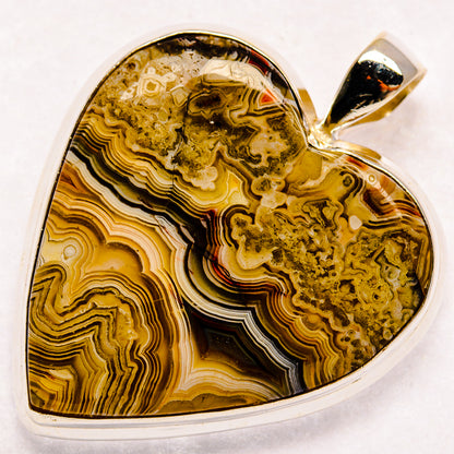 Sterling silver heart pendant with dark yellow agate slice and top bail
