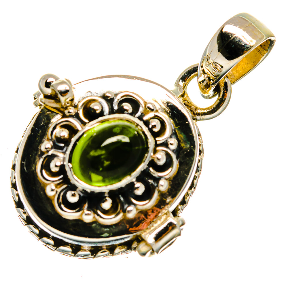 Silver pendant with green oval gemstone in ornate bezel, with gold-toned bail