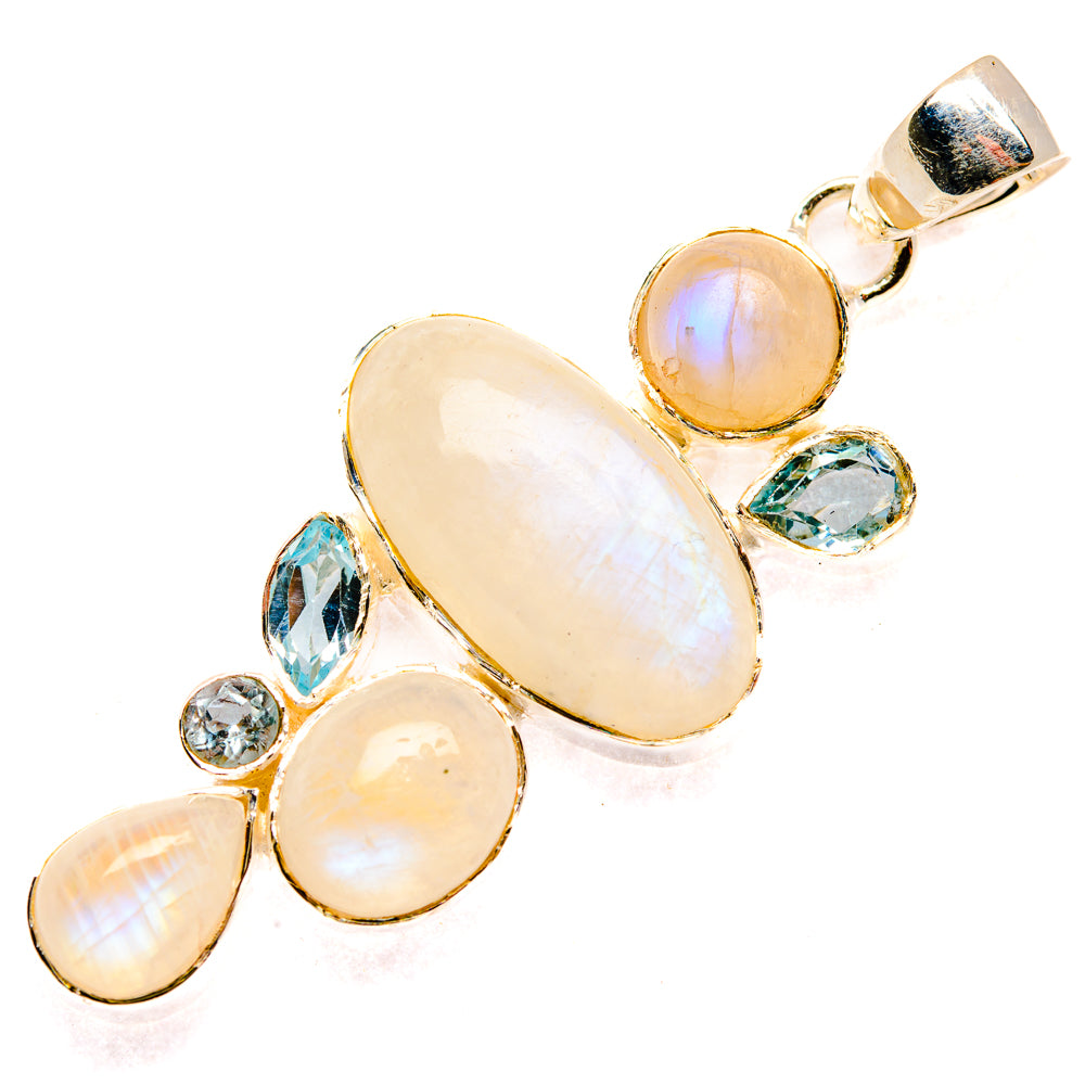 Oval rainbow moonstone pendant in gold-tone silver with blue topaz-like stones and bail