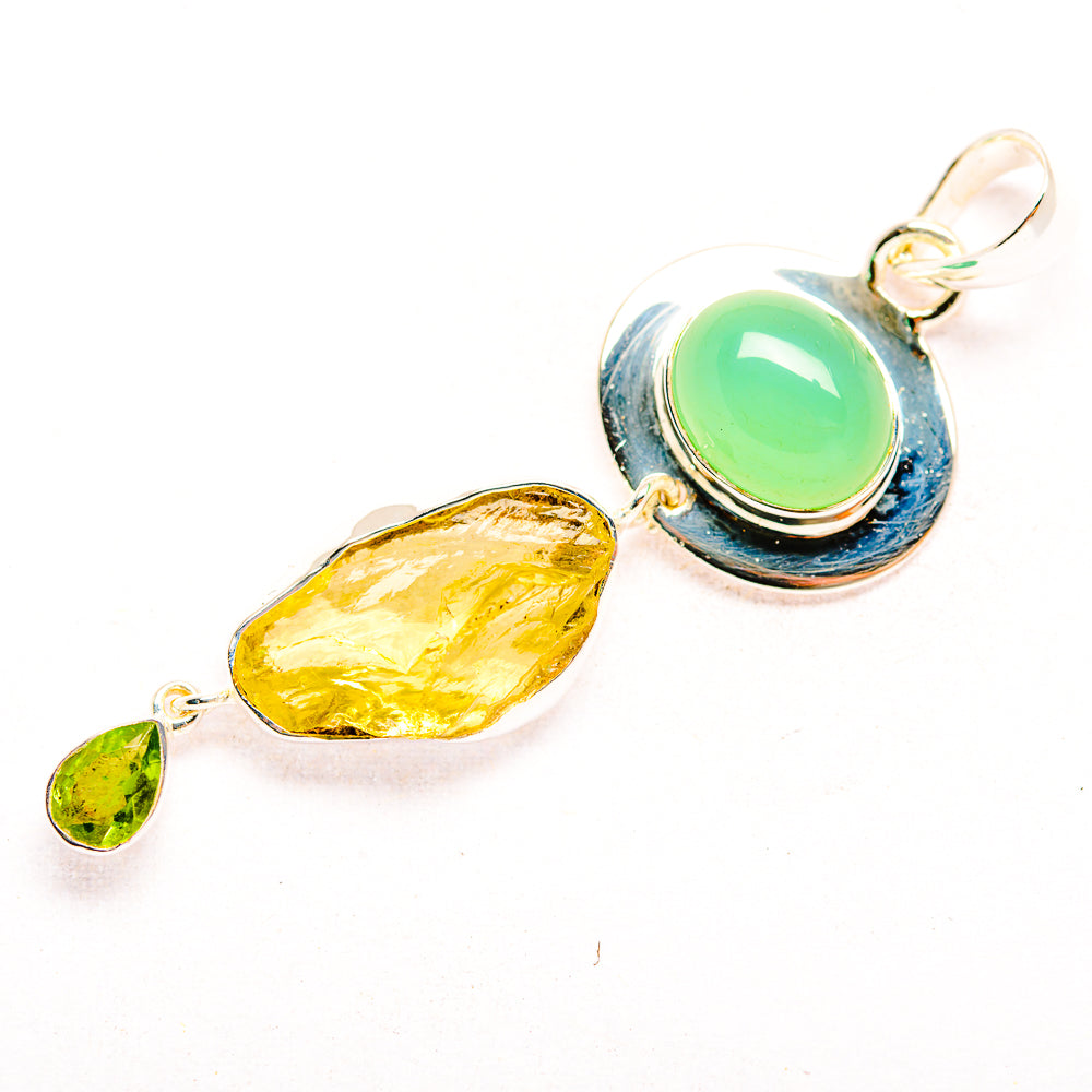 Sterling silver pendant with oval green cabochon, rough yellow stone, and small green charm
