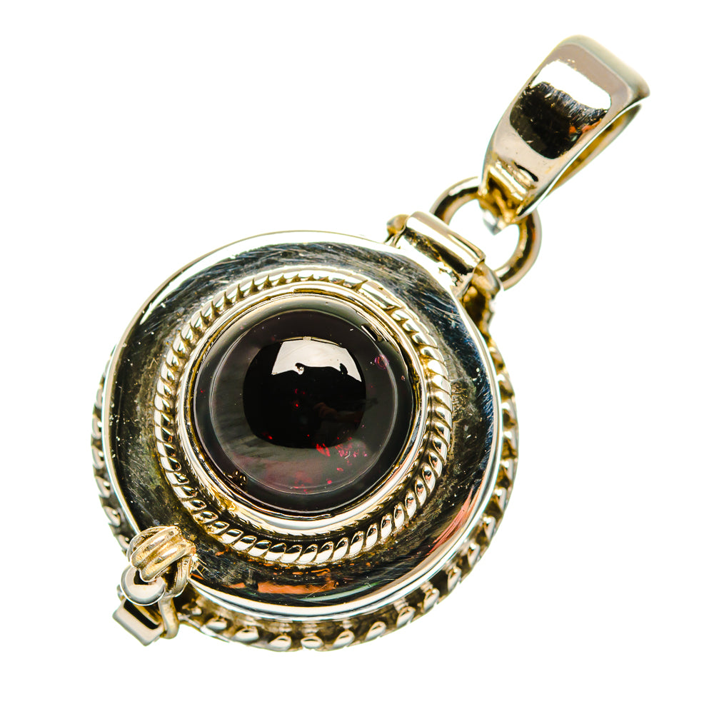 Sterling silver pendant with oval dark red gemstone and ornate rope border