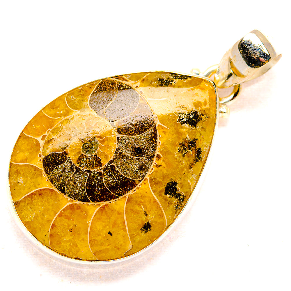 Fossil ammolite pendant with teardrop yellow stone and dark swirl pattern, silver bail
