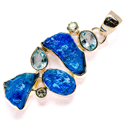 Blue rough stone pendant with oval and round clear gems in gold-tone setting