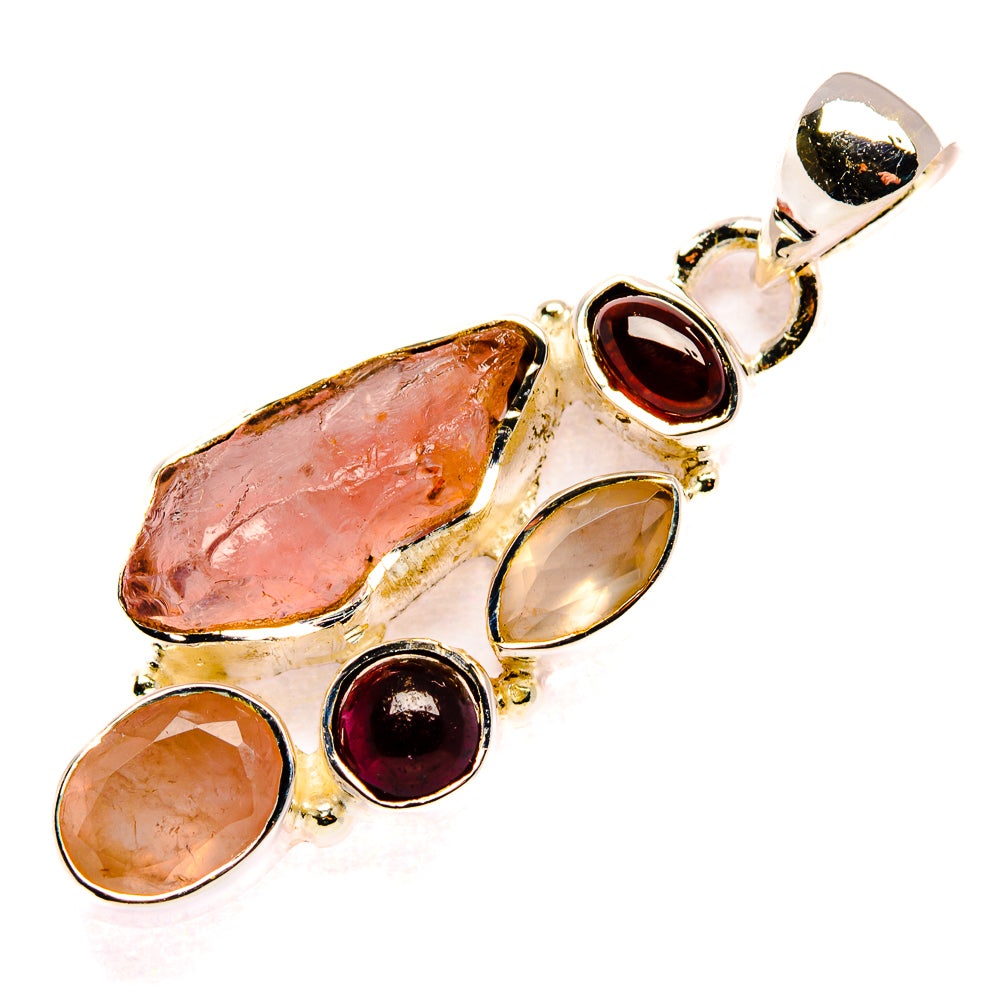 Sterling silver pendant with rough pink stone and multiple round red gemstones, bail top