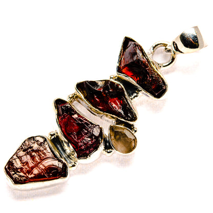 Rough dark red gemstone pendant with silver links and circular bail, clustered stones