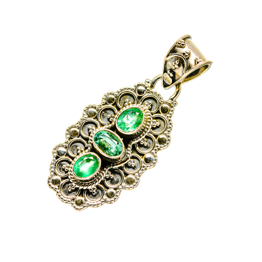 Oval green emerald pendant with detailed filigree border and top loop, gold-tone bail