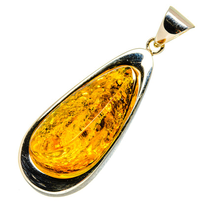 Teardrop Baltic amber pendant in polished silver setting with gold bail