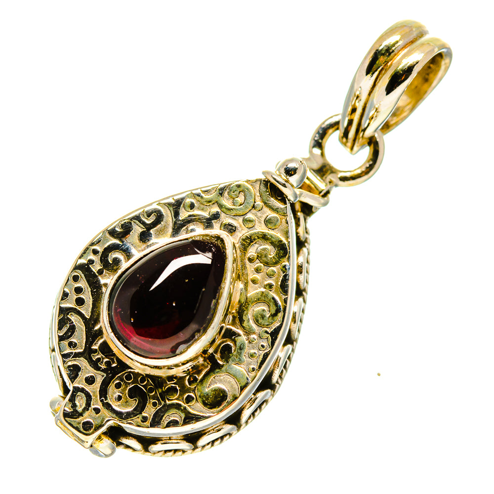 Teardrop garnet pendant with ornate scrollwork, dark red stone, and gold-tone bail