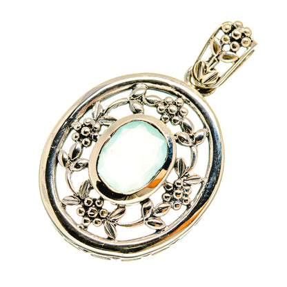 Sterling silver pendant featuring aqua oval cabochon stone in ornate round frame with bail