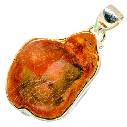 Petrified wood pendant with silver top bail; heart face shows amber, rust and green
