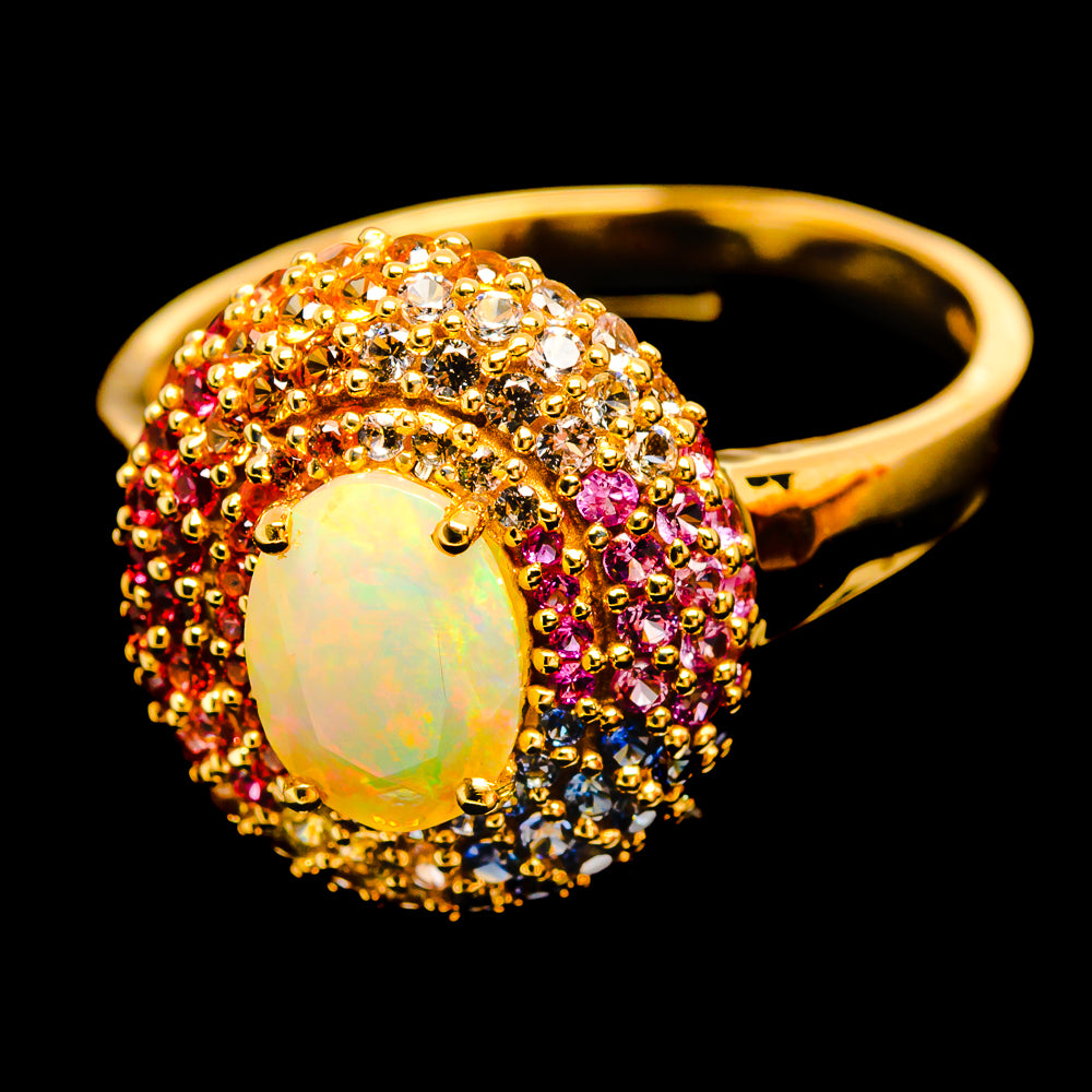 Yellow gold opal ring with oval opal bezel wrapped in multicolor sapphire clusters