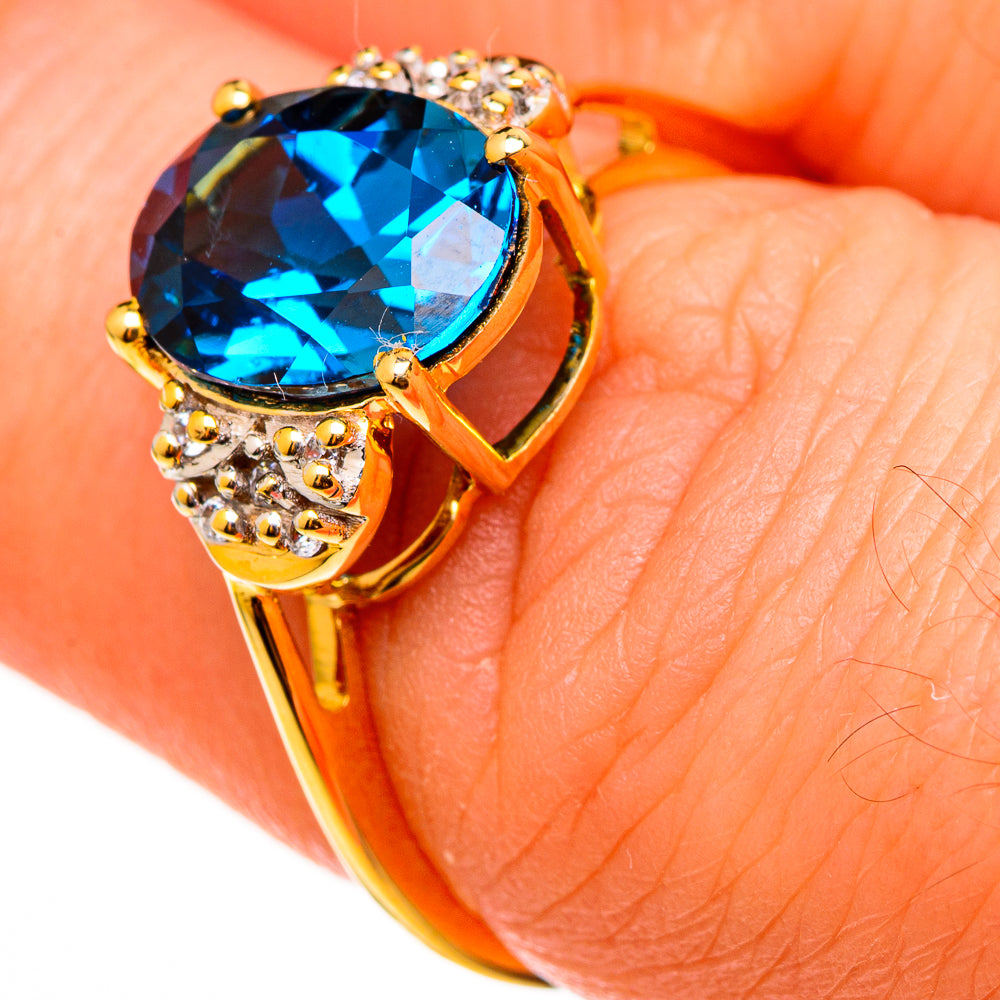 Gold ring with oval blue topaz center and white zircon detailing on the band