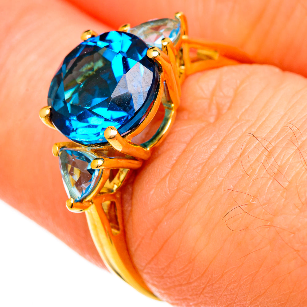 Gold ring close-up: oval blue topaz with two pear-cut blue topaz side stones