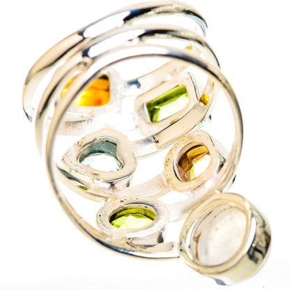Silver ring with oval moonstone and bezel-set green and yellow stones in openwork.