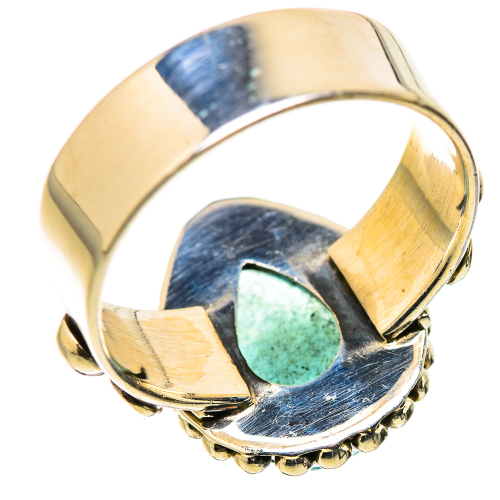 Gold-tone ring with oval green stone set in scalloped bezel