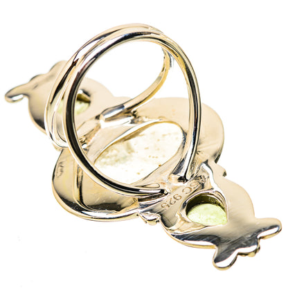 Sterling silver ring with large oval yellowish gemstone bezel and openwork side guards