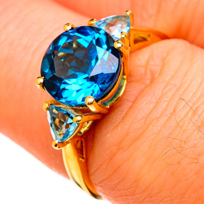 Gold ring close-up: large oval blue topaz with two teardrop blue topaz side stones