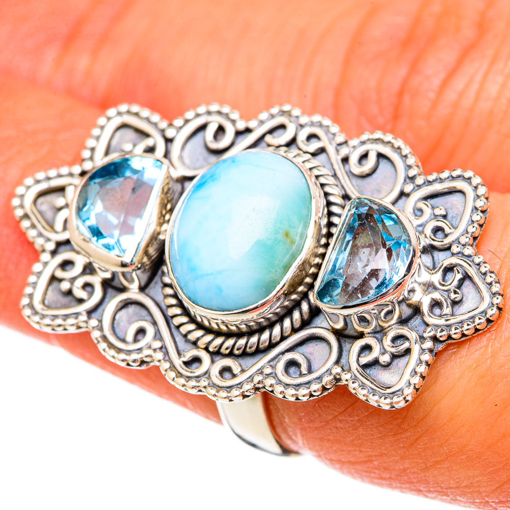 Sterling silver ring with oval sky-blue larimar center and two blue topaz stones