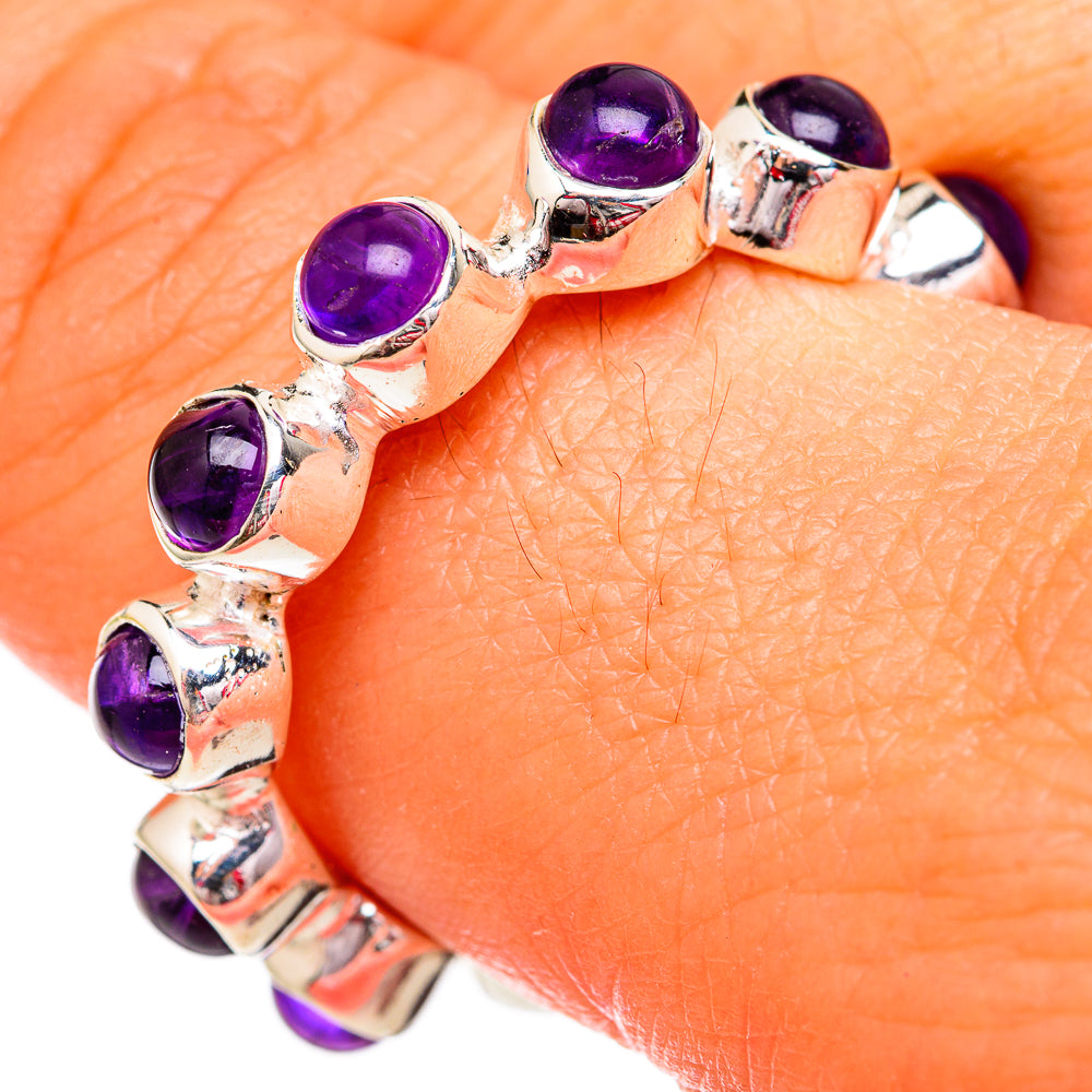 Amethyst sterling silver ring with oval purple gemstones on finger, close-up.
