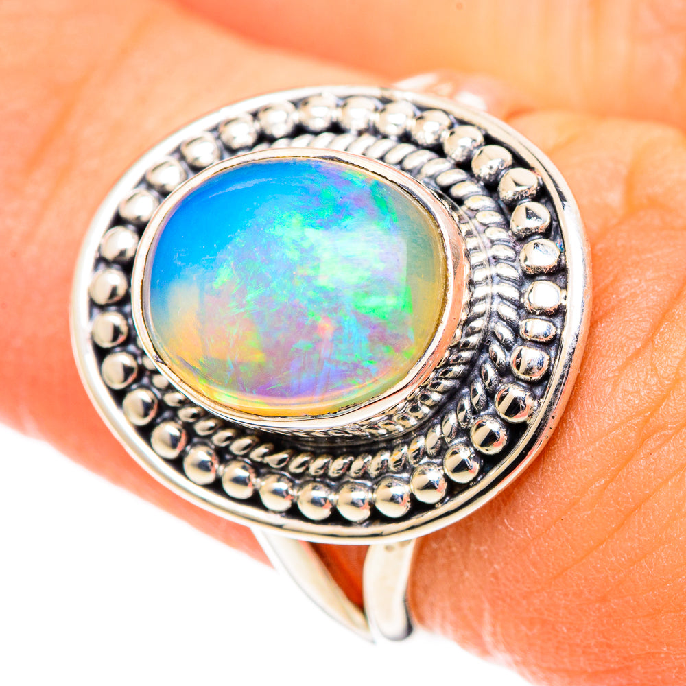 Oval opal ring in silver with detailed beadwork bezel and blue-green iridescence