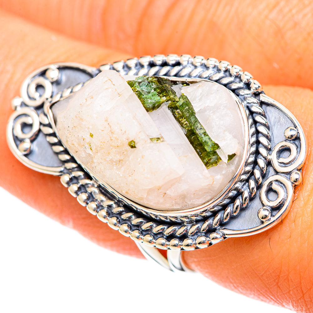 Silver oval ring with green tourmaline in quartz bezel and ornate rope border detail