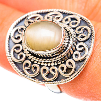 Oval moonstone cabochon ring with silver filigree and braided bezel on hand