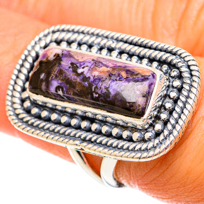Sterling silver ring angled view; rectangular purple mottled cabochon with beaded border.