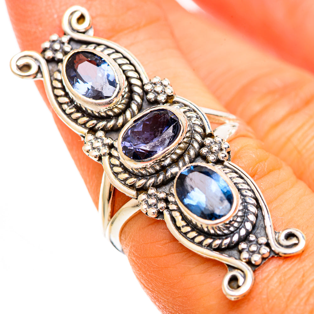 Sterling silver cuff-style ring with three oval faceted blue stones on hand