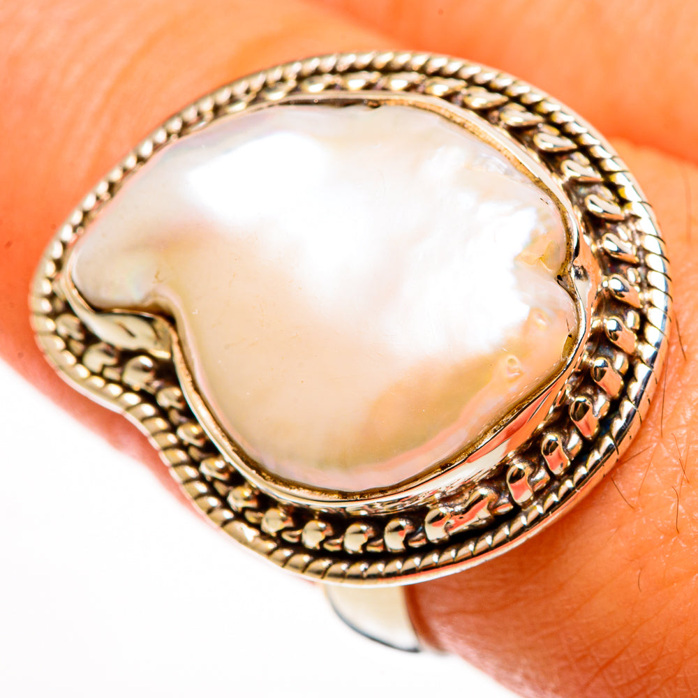 Oval mother-of-pearl cabochon set in textured rope-edge sterling silver ring bezel