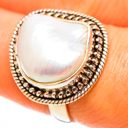 Mother-of-pearl teardrop ring with braided border and halo bezel, metallic setting