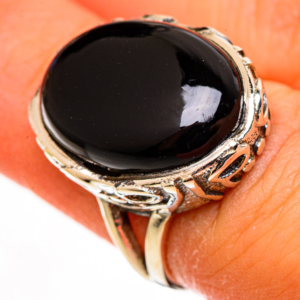 Black onyx ring with detailed silver side prongs and oval black gemstone bezel