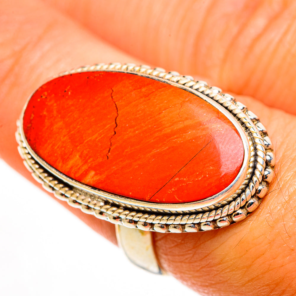 Close-up oval red jasper ring with braided rope bezel on gold-tone band