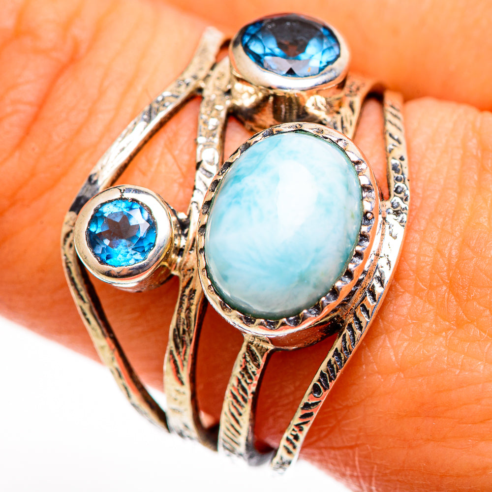 Sterling silver ring featuring large oval larimar with round blue gemstones, ornate bands