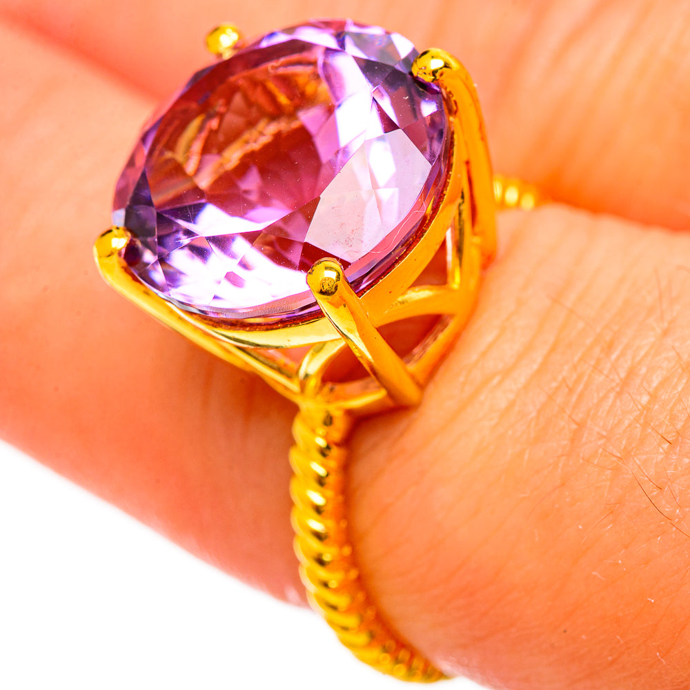 Gold-tone ring with faceted amethyst gemstone, round top with prong setting