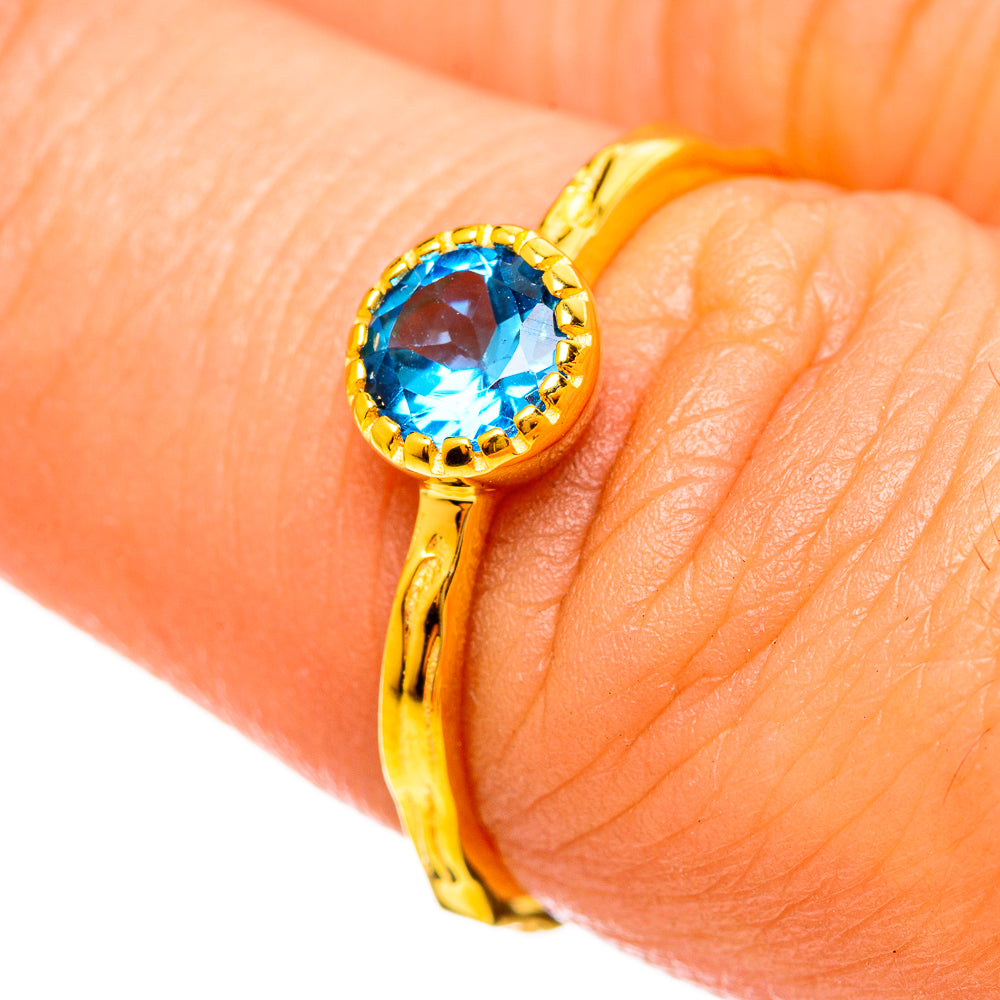 Gold-plated ring with round blue topaz gemstone and ornate bezel
