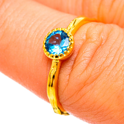 Gold-plated ring with round blue topaz gemstone and ornate bezel