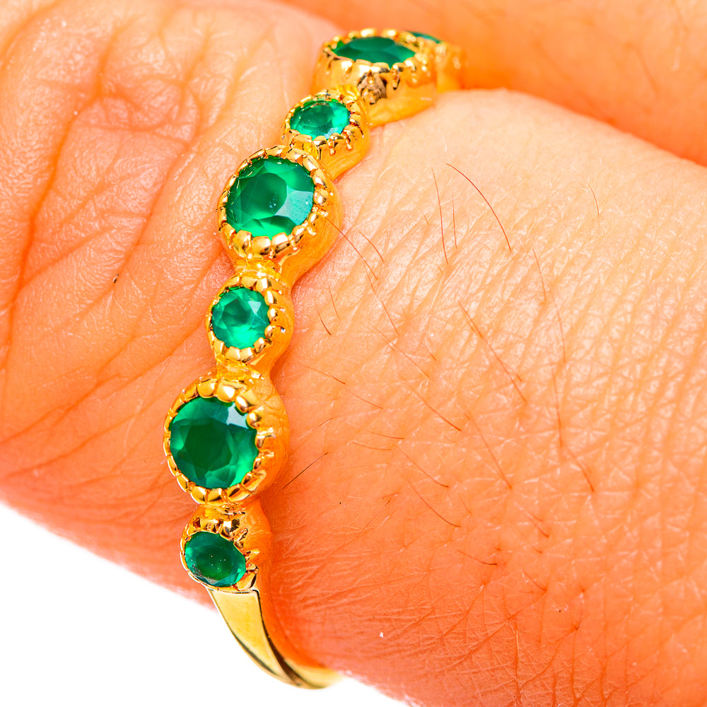 Gold plated green onyx style gemstone ring with oval cut stones, close-up on finger