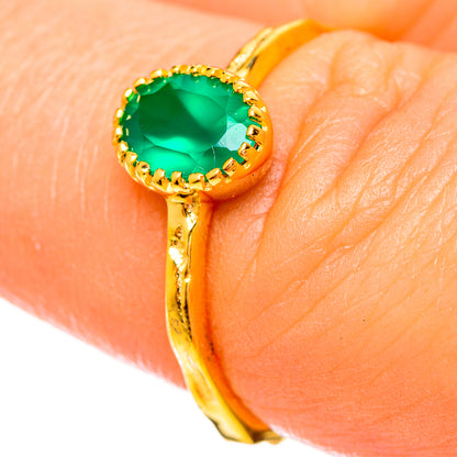 Gold-plated green onyx oval ring close-up on finger, scalloped gold setting