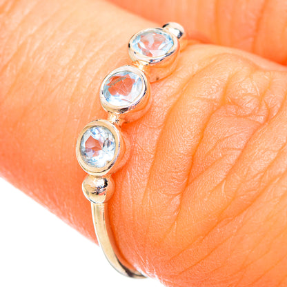 Sterling silver ring on finger with three oval blue stones and polished band