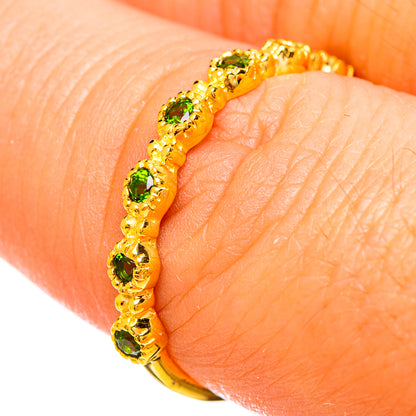 Gold plated diopside ring on finger, green round stones in a gold setting