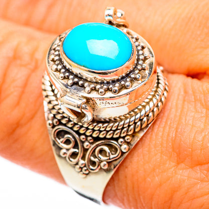 Turquoise oval gemstone ring with raised halo and scrollwork, silver-tone band