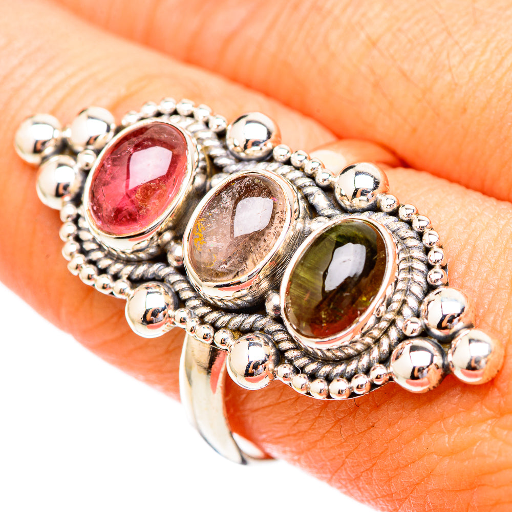 Close-up sterling silver ring with three oval stones in pink, smoky, and green hues, beads