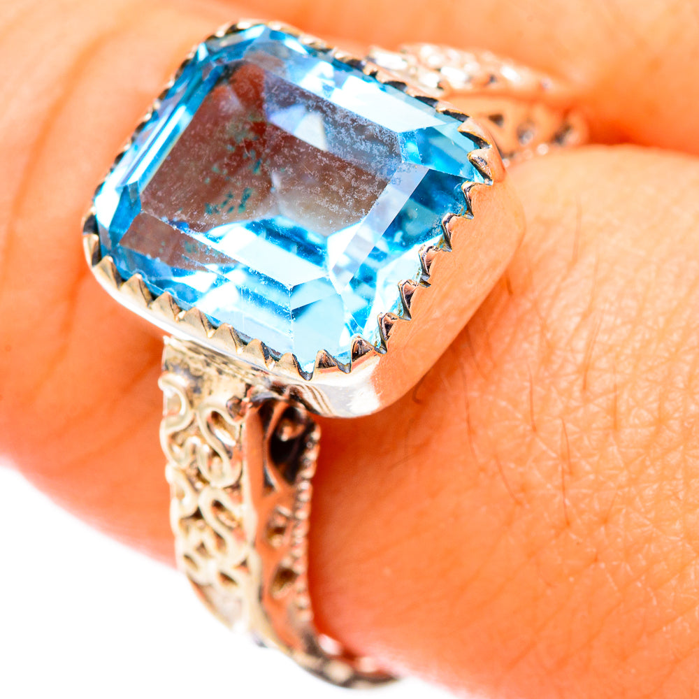 Blue topaz sterling silver ring with square-cut gemstone, ornate openwork band.